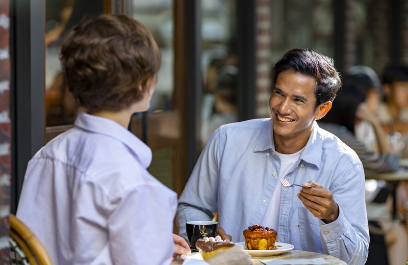 A couple sharing coffee and pastries at a pavement café